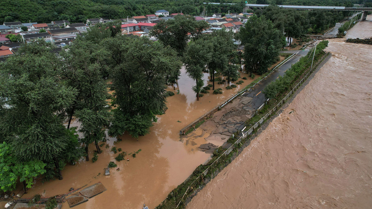 বন্যায় বেইজিংয়ের রাস্তাগুলো পরিণত হয়েছে নদীতে